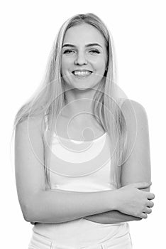 Studio shot of young happy teenage girl smiling with arms crossed