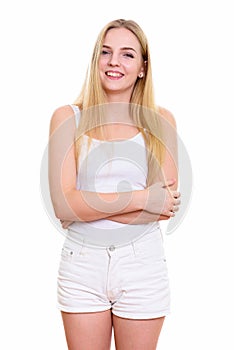 Studio shot of young happy teenage girl smiling while standing w