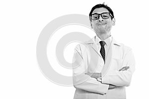 Studio shot of young man doctor with arms crossed