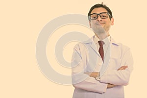 Studio shot of young man doctor with arms crossed