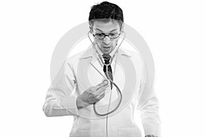 Studio shot of young man doctor using stethoscope on himself while looking shocked