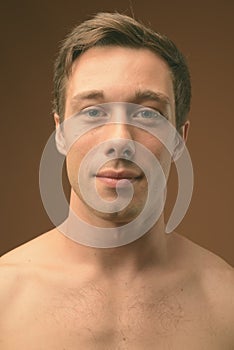 Studio shot of young muscular handsome man shirtless in black and white