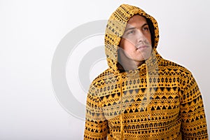 Studio shot of young muscular man wearing hoodie while thinking