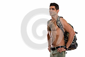 Studio shot of young muscular Persian man posing shirtless with