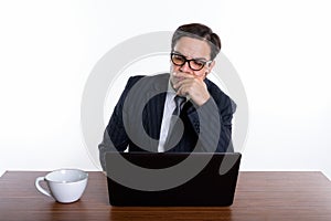 Studio shot of young Persian businessman wearing eyeglasses whil