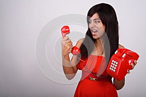 Studio shot of young Persian woman looking angry while shouting