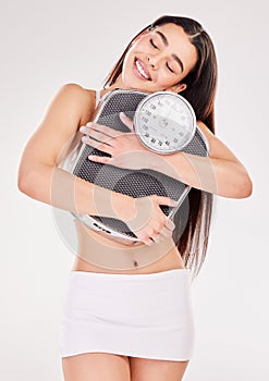 Studio, wellness or happy woman with fitness or scale for body training or gym workout to lose weight. Girl, monitor or