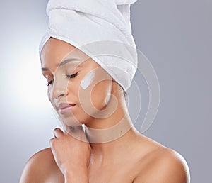 Studio, woman and towel for cream or cosmetics, moisturizer and hand on white background. Skincare, dermatology and