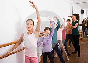 Studious boys and girls rehearsing ballet dance in studio