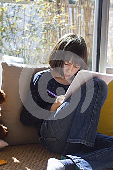 Studious child writing, drawing or studying home while class shutdown