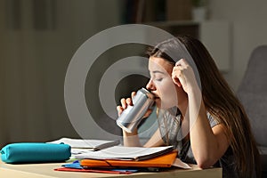 Studious teen studying drinking energy beverage photo