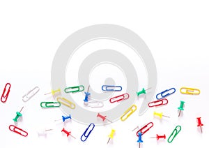 Study concept background. Colorful office stationery: drawing pins and clips on white background with copy space