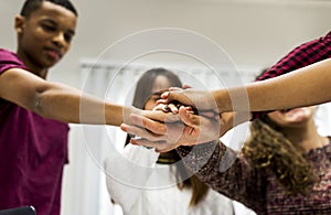 Study group classmates joining hands together