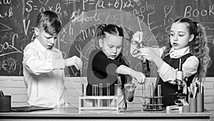 Study of liquid states. Group school pupils study chemical liquids. School laboratory. Girls and boy conduct experiment