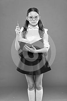 Study literature. Pupil likes study. Small girl enjoying her school time. Happy little schoolgirl ready for lesson. Cute