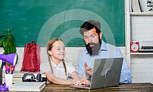 Study modern technologies. School teacher and schoolgirl with laptop. Man bearded pedagogue teaching informatics