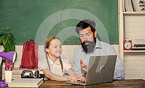 Study modern technologies. School teacher and schoolgirl with laptop. Man bearded pedagogue teaching informatics