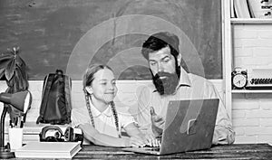 Study modern technologies. School teacher and schoolgirl with laptop. Man bearded pedagogue teaching informatics