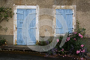 A study of an old blue wooden door and shuttered window
