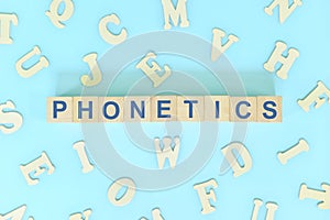 Study phonetics in linguistics concept. Wooden blocks word typography flat lay in blue background.