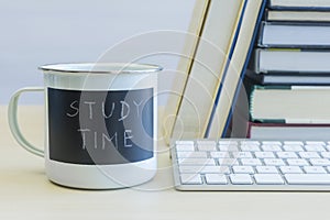 Study time words on mug with keyboard and books