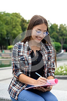 A young white woman in a plaid shirt and eyeglasses