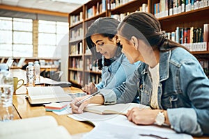Studying together can sometimes be easier. two young female university students studying in the library.