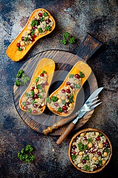 Stuffed butternut squash with chickpeas, cranberries, quinoa cooked in nutmeg, cloves, cinnamon. Thanksgiving dinner recipe.