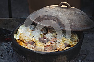 Stuffed cabbage rolls boiled in clayware pot on simmering ashes photo