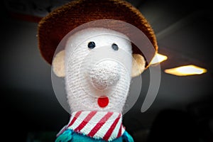 Stuffed cowboy with an extremely surprised look. Small red mouth and black beady eyes. Typical decoration for the rear-view mirror