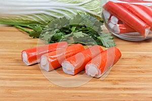 Stuffed crab sticks on cutting board against of vegetables