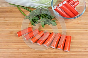 Stuffed crab sticks on cutting board against of vegetables