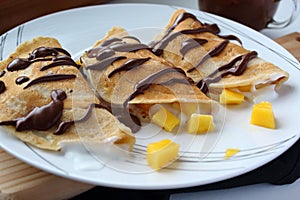 Stuffed crepes with mango, vegetal yogurt and chocolate.