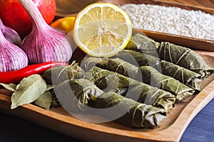 Stuffed delicious dolma with ingredients and lemon on wooden Board