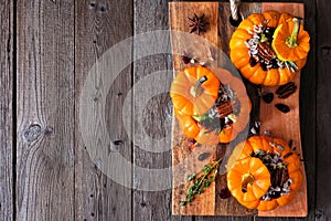 Stuffed fall mini pumpkins with rice, cranberries, cabbage and nuts above view on platter over rustic wood