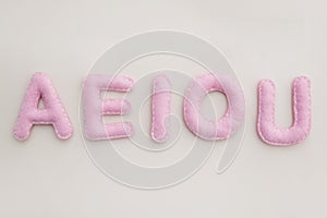 Stuffed felt letters, the vowels of the alphabet.