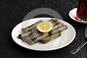 Stuffed grape leaves on dark background. Dolma sarma on plate