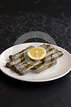 Stuffed grape leaves on dark background. Dolma sarma on plate