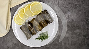 Stuffed grape leaves with olive oil on a dark background. Delicious dolma yaprak sarma.