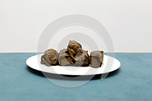 Stuffed grape leaves traditional doom Mediterranean cuisine Dolma on white plate with sauce