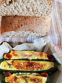 Stuffed green zucchini with cheese and eggs seasoned with grated cheese pepper rosemary and chily tomatoes baked in the oven