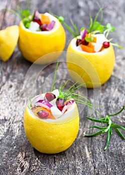 Stuffed lemons with vegetarian salad on the old table