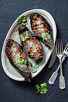 Stuffed lentils roasted eggplant - delicious healthy vegetarian lunch, snack, appetizer on a dark background
