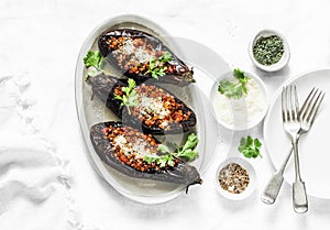 Stuffed lentils roasted eggplant - delicious healthy vegetarian served lunch table. On a light background