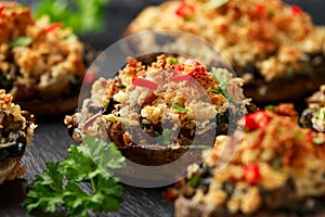Stuffed mushrooms with spinach, bread crumbs and cheese on stone board