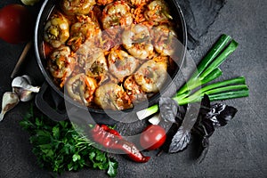 Stuffed peppers with rice, meat and spices in a dark pan on a dark background