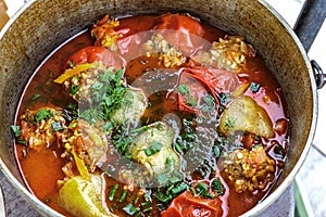 Stuffed peppers and tomatoes cooked in a cast-iron cauldron with water. Healthy homemade food. Tasty summer food