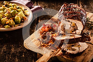 Stuffed pork sliced with bacon on cutting board