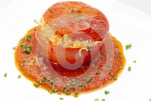 Stuffed tomato with sauce and chive garnish