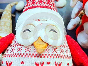 Stuffed toy penguin with a red pattern, narrowed eyes and an orange beak.